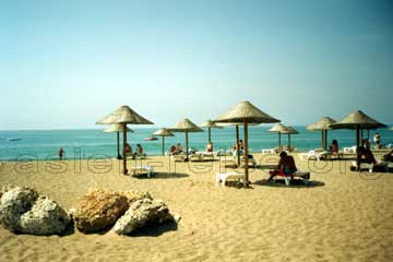 Strand, Badeurlauber, Sonnenliegen und Sonnenschirme im Süden am Mittelmeer bei Antalya an der Türkischen Rivera.